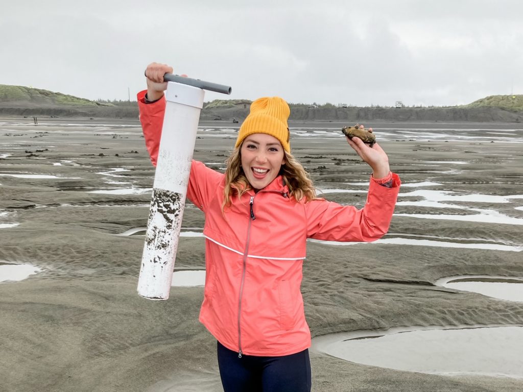 Author holding PVC clam gun and a razor clam.