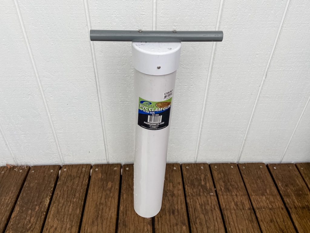 Clam gun for digging razor clams, made of one long white PVC piece and a gray handle.