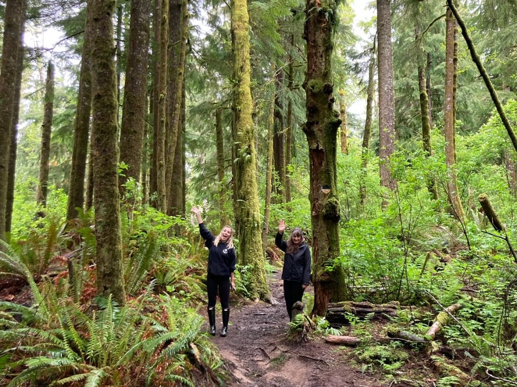 Author and mother waving on the Cathedral Tree Trail, one of the free things to do in Astoria, Oregon.