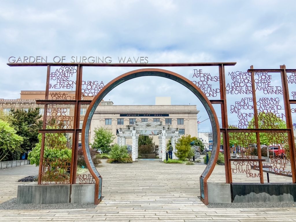 Bronze arch known as a moon gate, marking the entrance to the Garden of Surging Waves in Astoria, Oregon.
