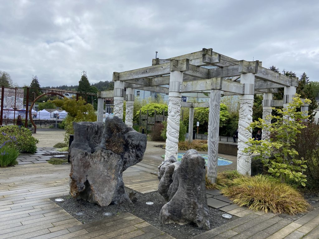 Marble gazebo, petrified tree trunks, and foliage line the inside of the Garden of Surging Waves in Astoria, Oregon.