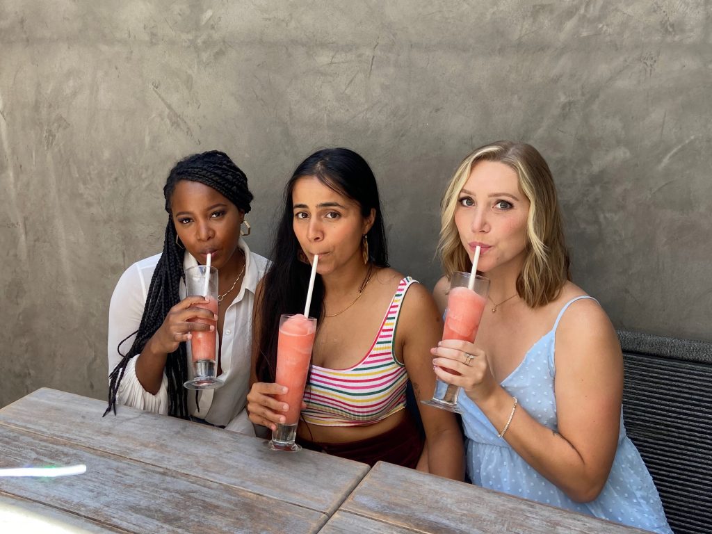Three girls who became friends through Bumble BFF sip on frozen strawberry daquiris.