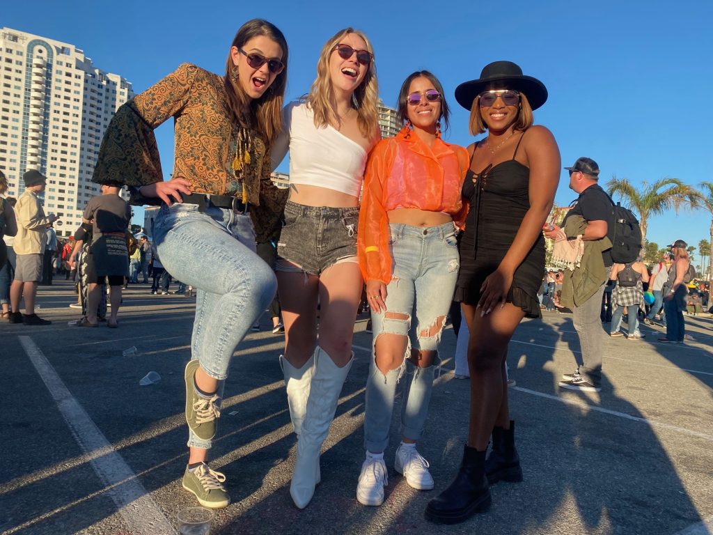 Four girls who became friends through Bumble BFF pose at a reggae festival in Long Beach, CA.