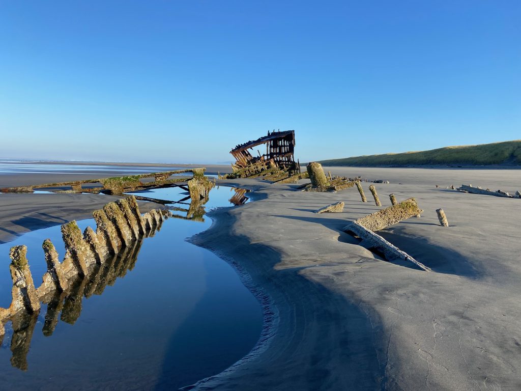 The shipwreck of the Peter Iredale sits in the sand at low tide at Fort Stevens State Park in Oregon.